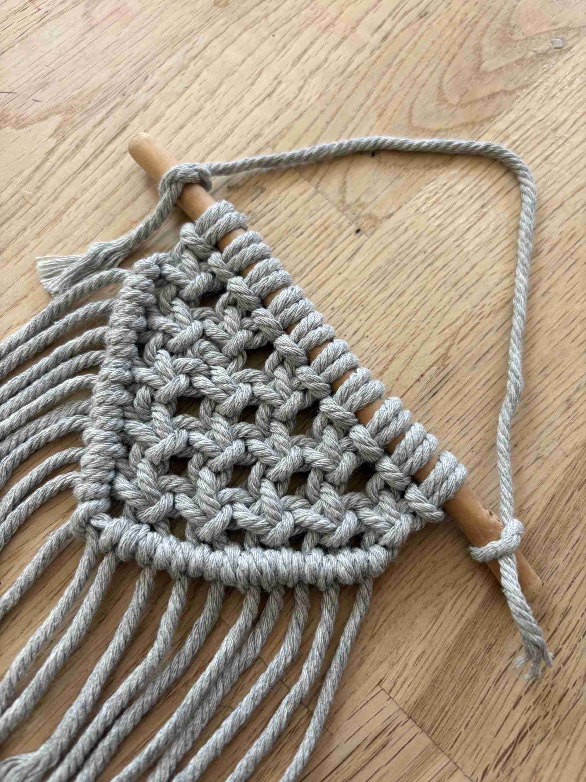 A macrame decorations, made of grey thread.